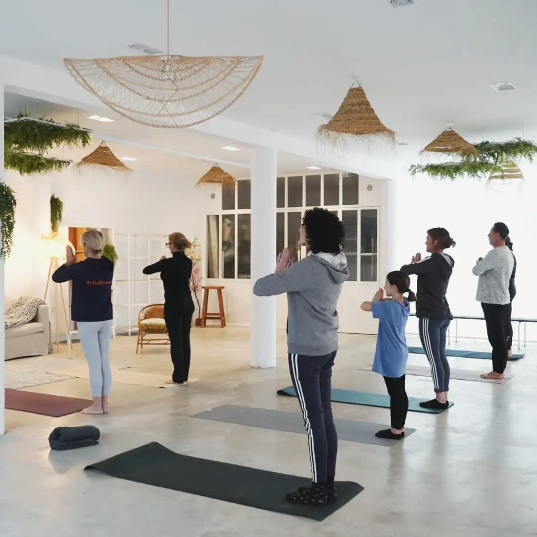 Cours collectif de yoga à Tarnos, pratiquants debout en posture d'ouverture
